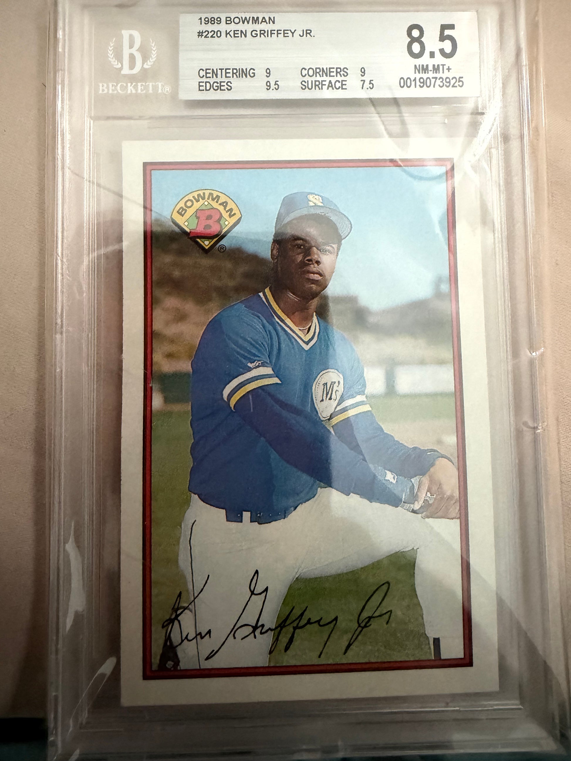 Baseball trading card of a player in a blue uniform with a signature, graded 8.5.