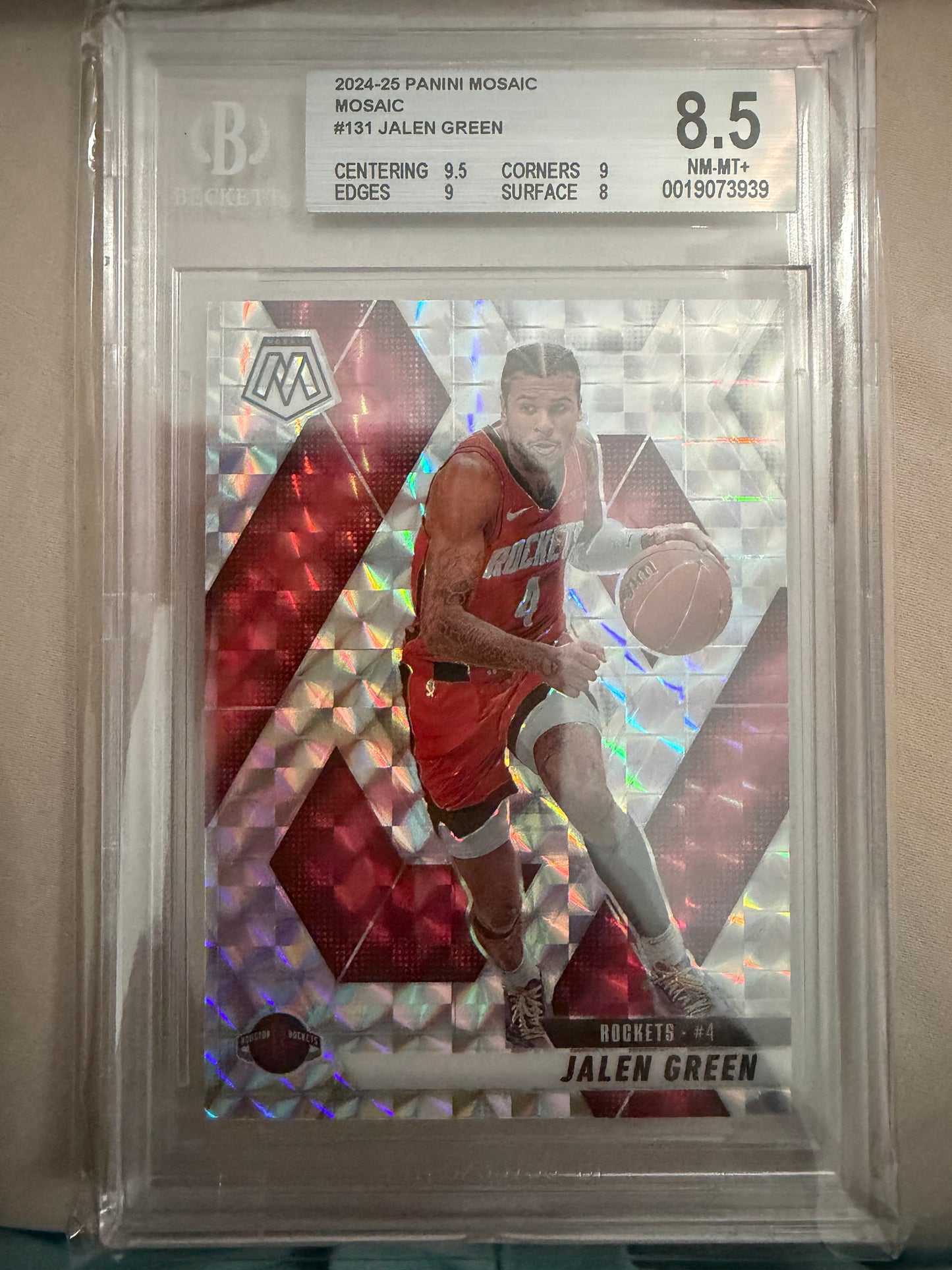 Basketball trading card of a player in a red jersey with a holographic design, encased in clear plastic.