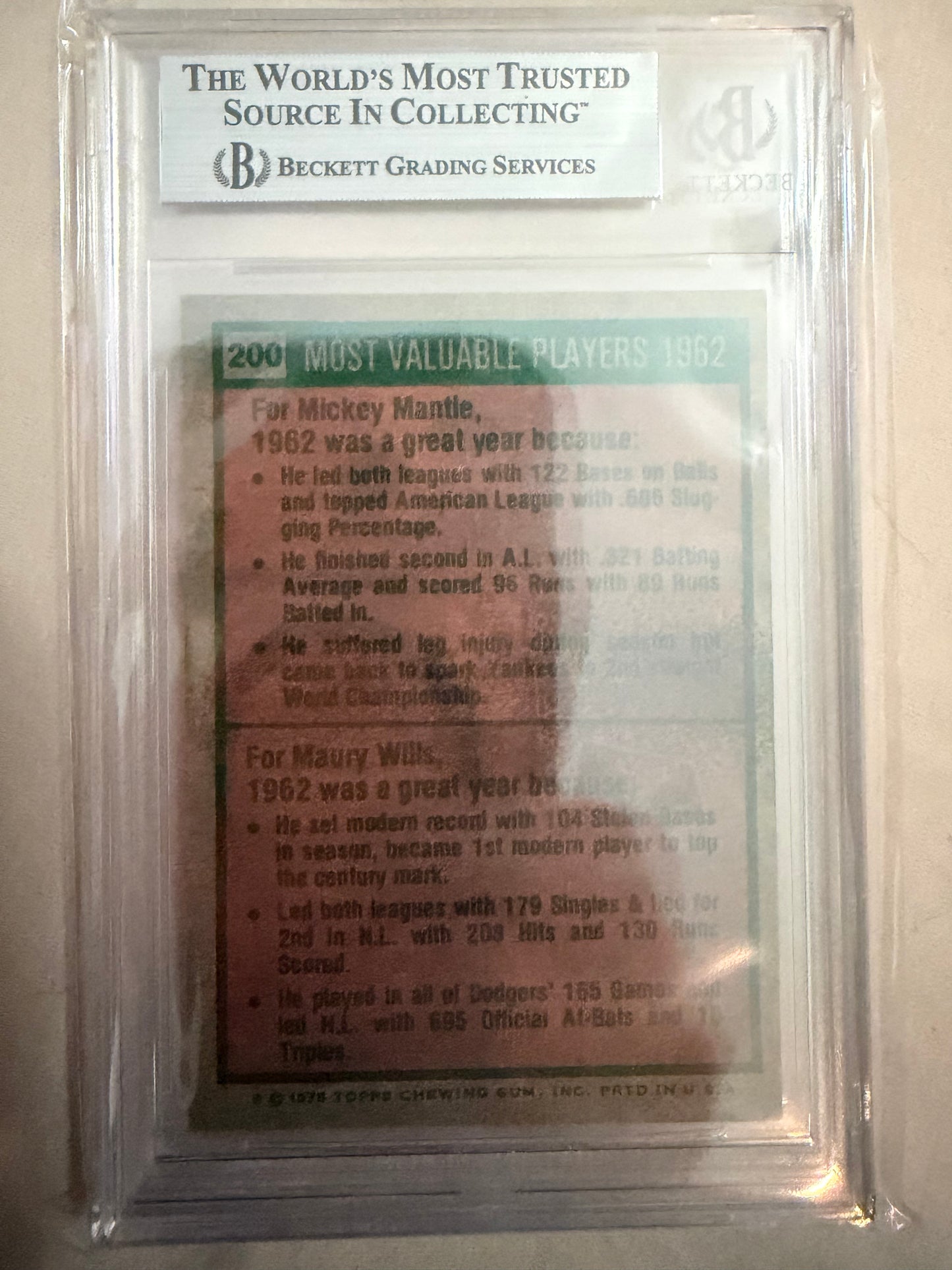 Baseball card in a protective case with text and a logo on a white background